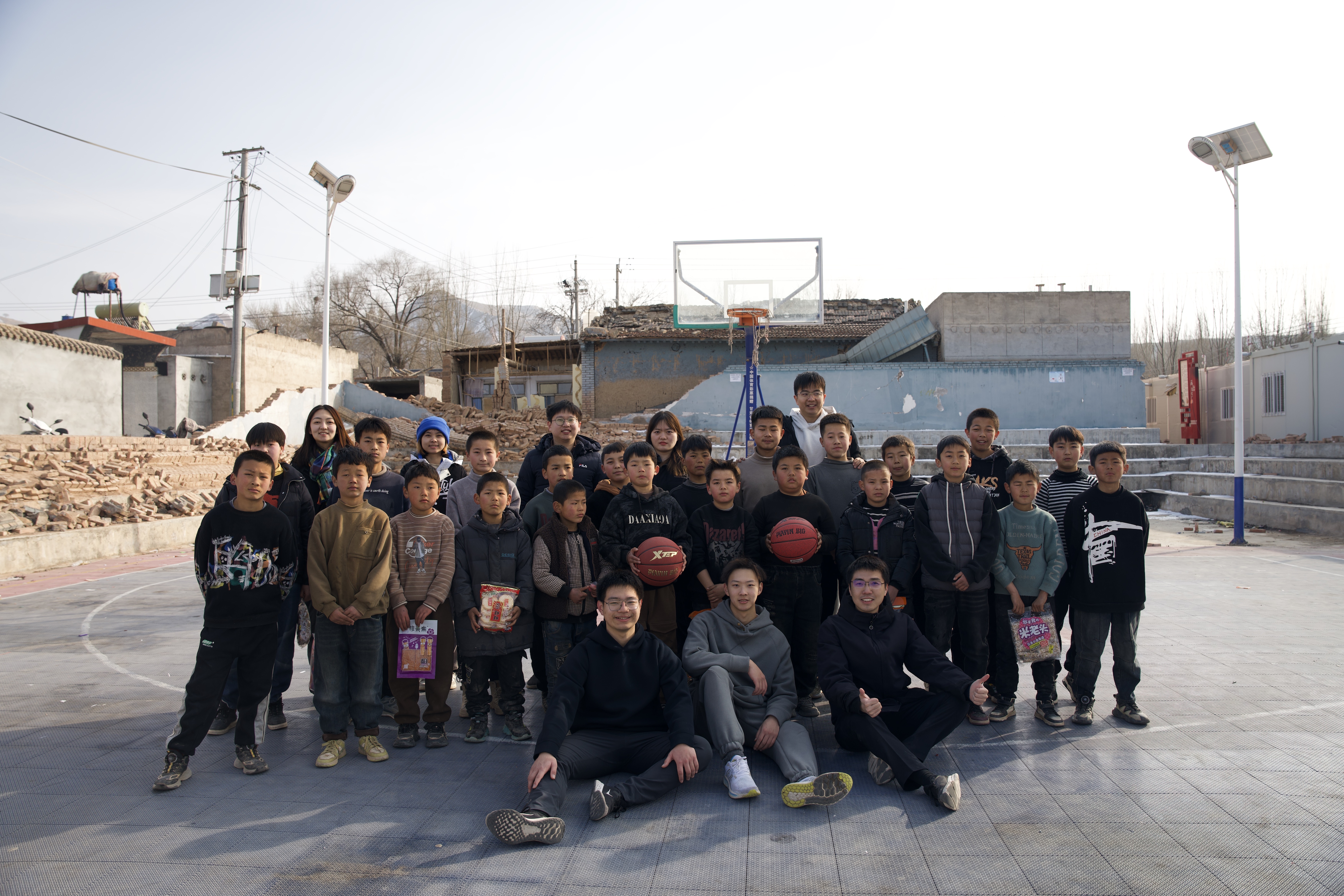 20240219-学思践悟挺膺行,青春建功新时代——2024年开云线上(中国)网页版研究生寒假社会实践纪实(一)-“社稷担当·心泽河州”实践支队-支队成员在在震区球场组织开展“青少年村BA”篮球赛.jpg